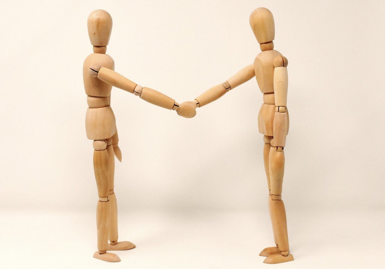 Wooden people figures shaking hands