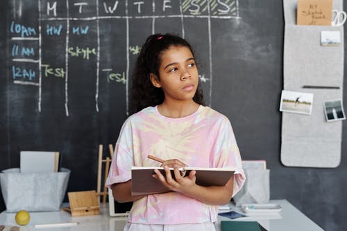 Girl thinking well writing in class
