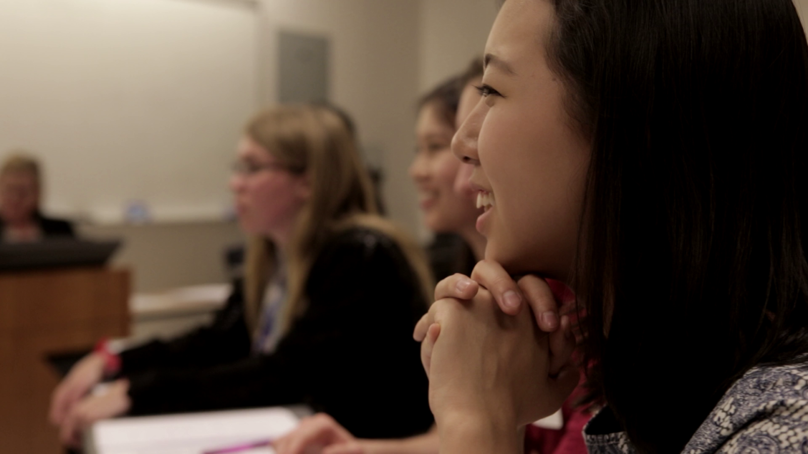 Photograph of a row of students smiling and engaging in philosophical dialogue in a classroom